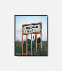 Framed western wall art featuring “Unload Gun” sign in desert landscape, rustic decor