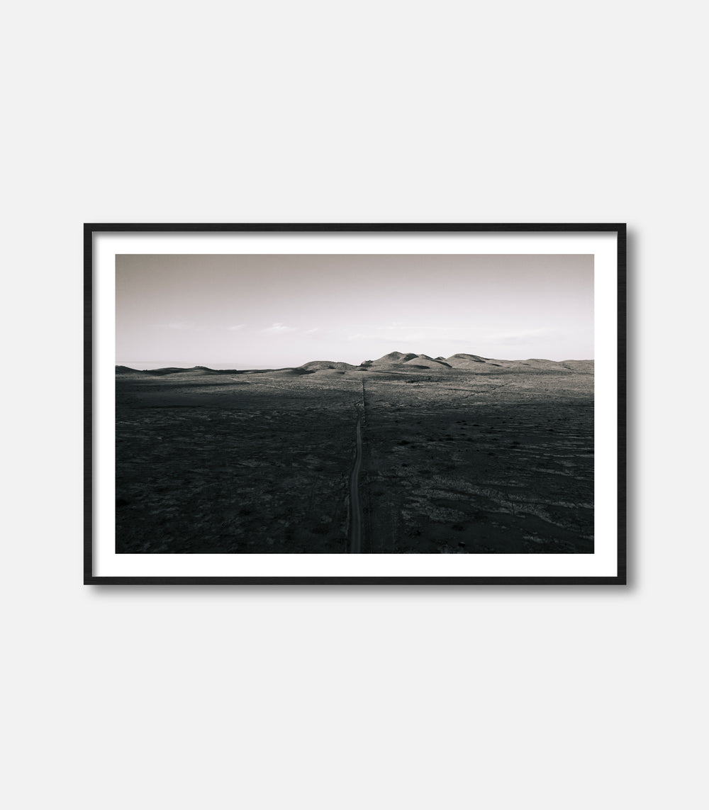 Black and white desert landscape wall art with distant hills