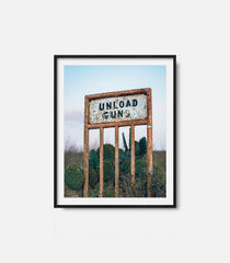 Framed western wall art featuring “Unload Gun” sign in desert landscape, rustic decor