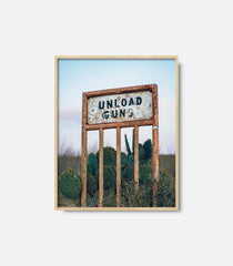 Framed desert wall art showing vintage “Unload Gun” sign, western rustic decor